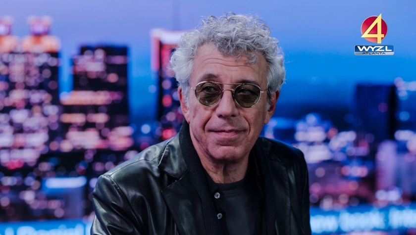 Eric Bogosian as an older Daniel Molloy, appearing on a WYZL Atlanta news broadcast set