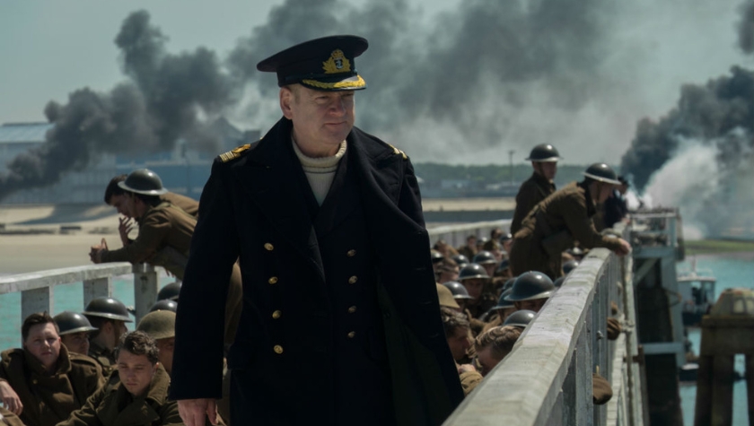 A naval officer on the mole surrounded by soldiers in 'Dunkirk' (2017)