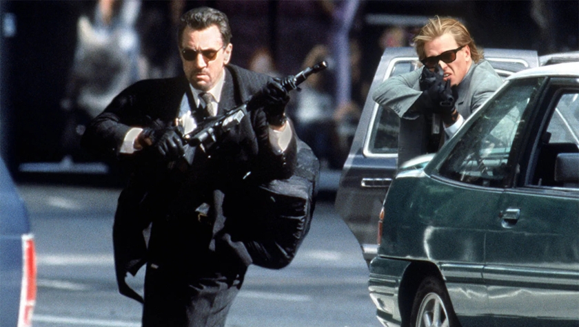 Neil McCauley (Robert De Niro) and Chris Shiherlis (Val Kilmer) during the armored car heist shootout in Heat