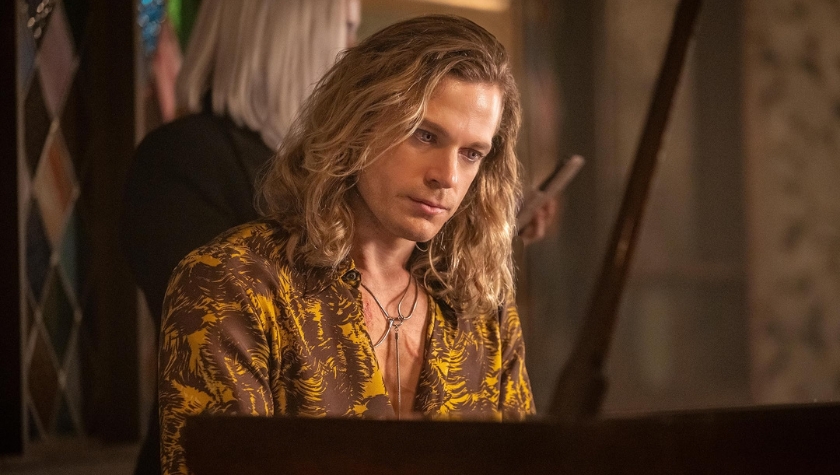 Sam Reid as Lestat, seated at a piano