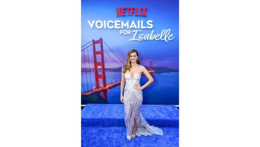 Zoey Deutch at the Netflix Voicemails for Isabelle premiere, standing in front of the film's backdrop featuring the Golden Gate Bridge