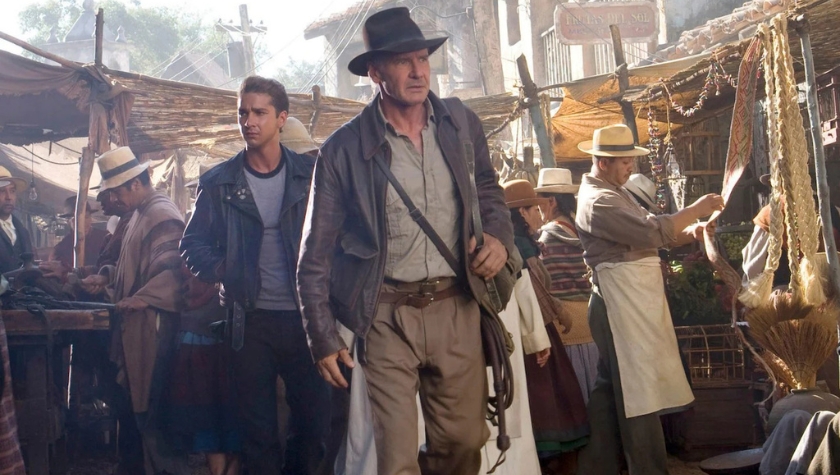 Indiana Jones and a young companion walk through a crowded outdoor market in Indiana Jones and the Kingdom of the Crystal Skull